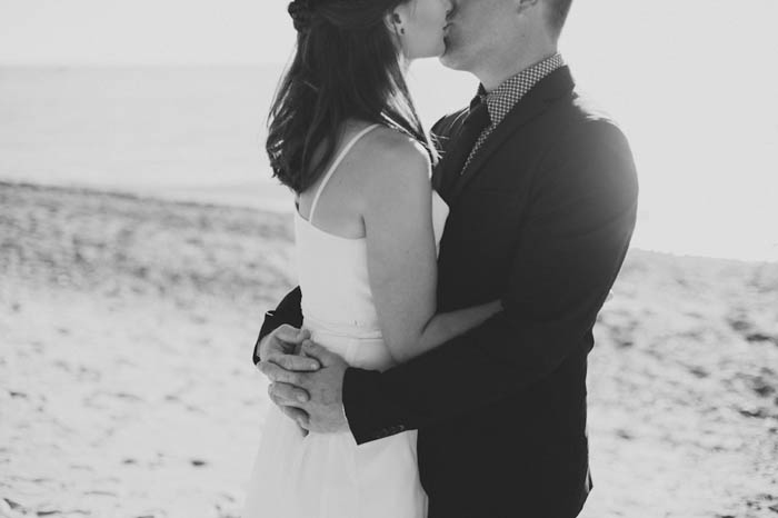 bride and groom kissing on the beach