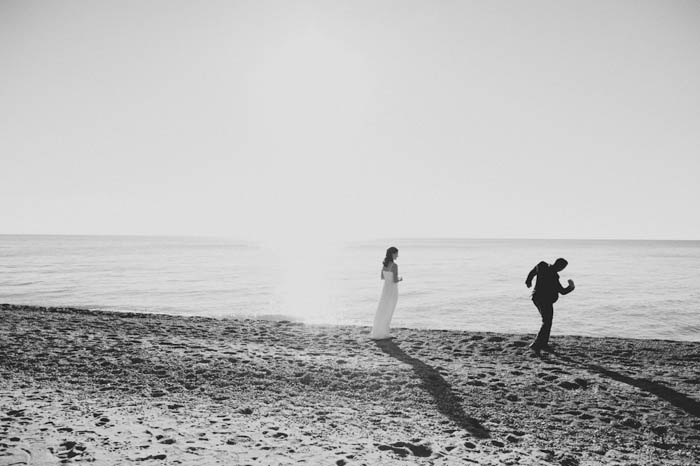 bride and groom skipping rocks on the beach