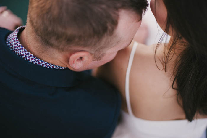 groom kissing bride's shoulder