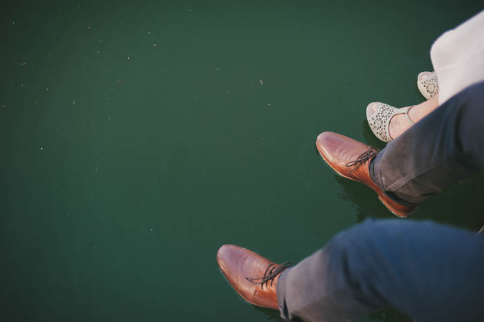 bride and groom's feet hanging off the dock