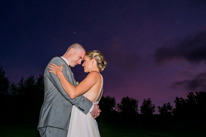 bride and groom portrait against purple sky