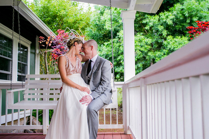 bride and groom sitting on porch swing