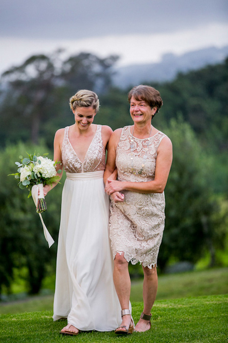 bride walking to ceremony with her mother