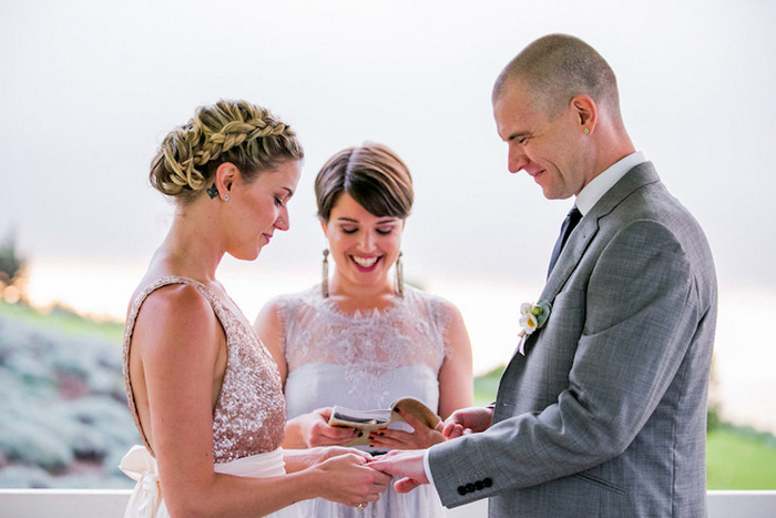 bride putting ring on groom's finger