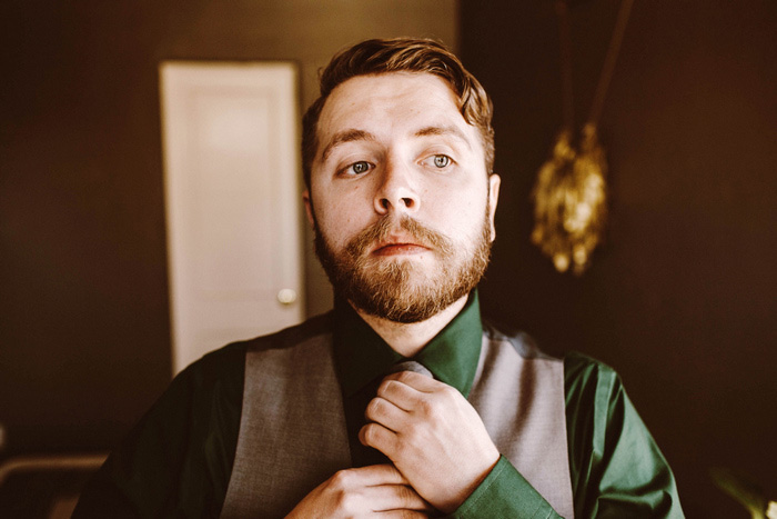 groom adjusting tie