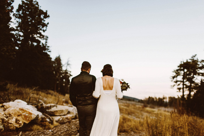 bride and groom walking up mountain