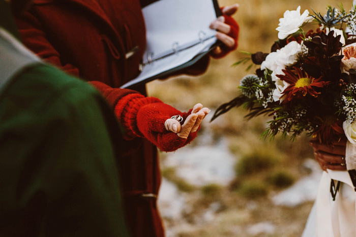 officiant holding out wedding rings