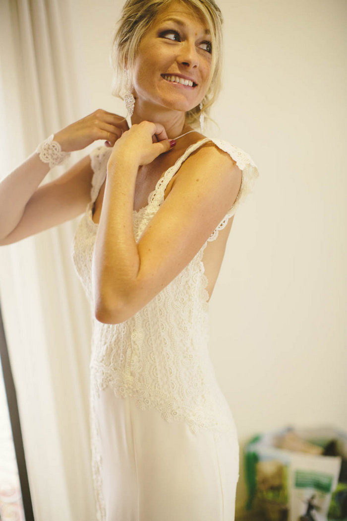 bride putting on necklace