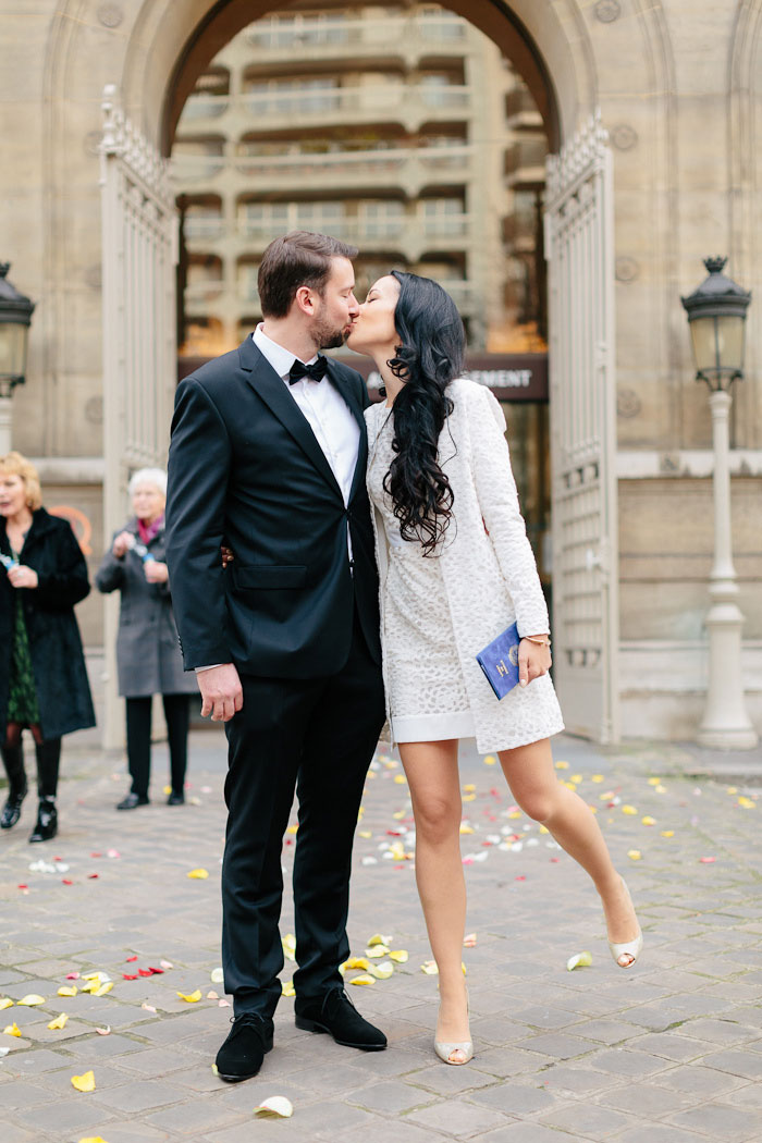 bride and groom kissing in front of city hall