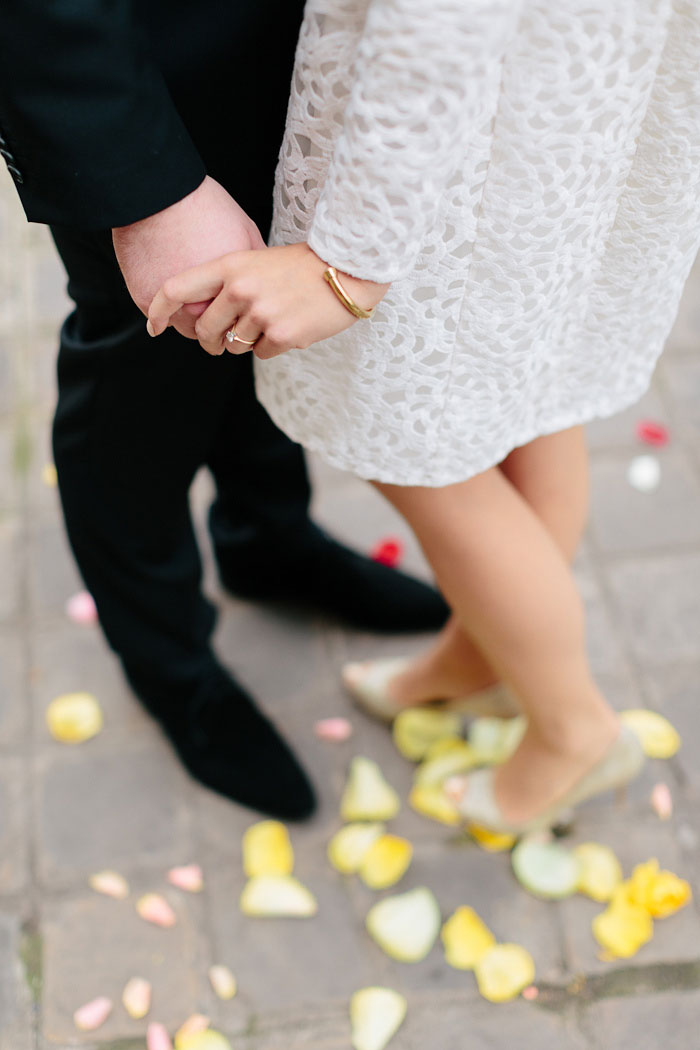 bride and groom standing on yellow rose petals