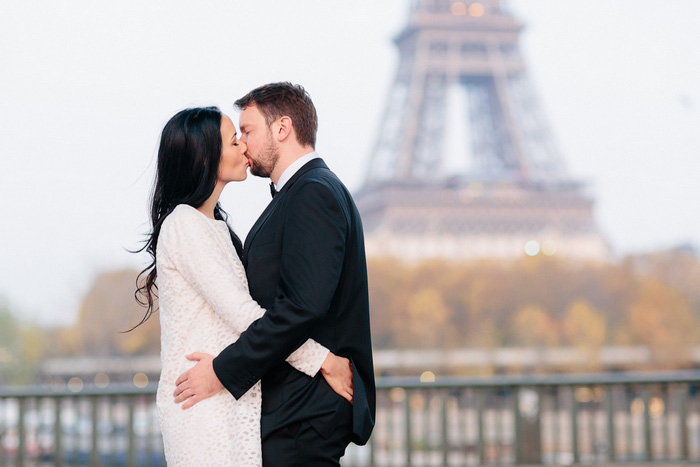 bride and groom kissing in front of eiffel tower