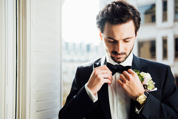 groom adjusting bow tie
