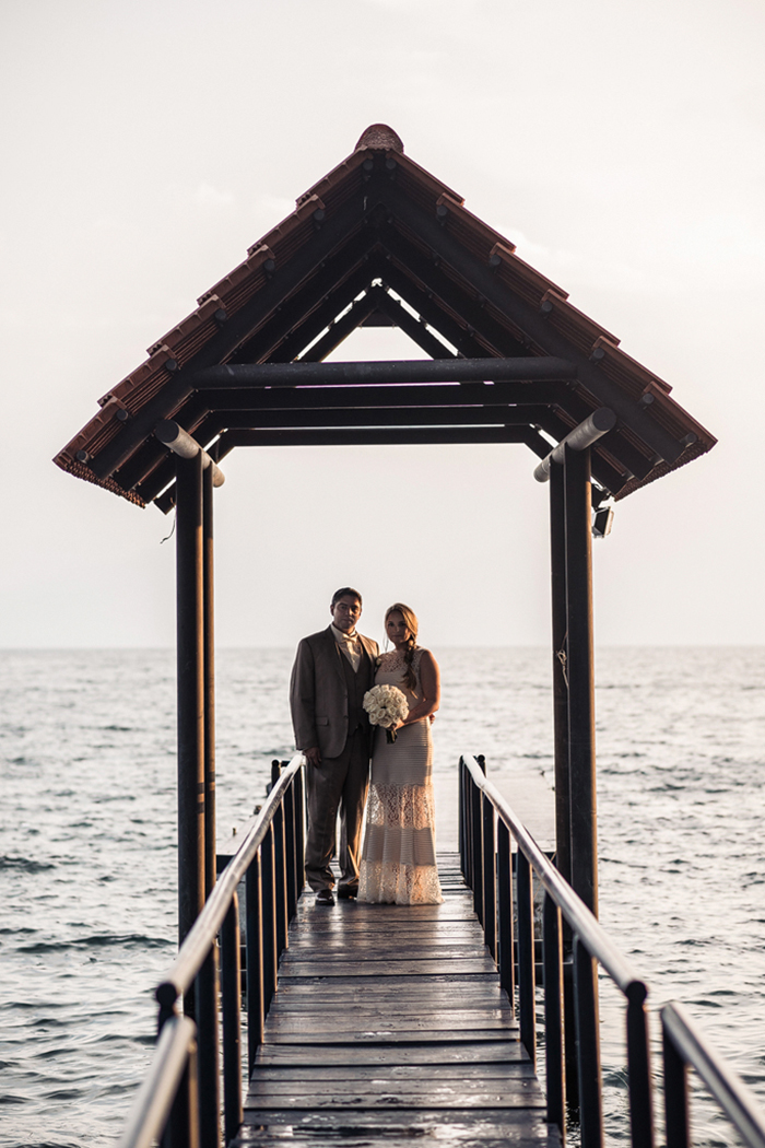 bride and groom on lake pier