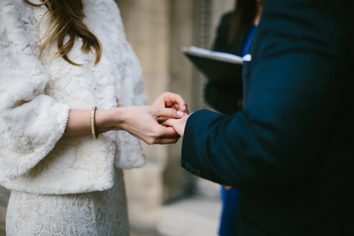 bride puttingring on groom's finger