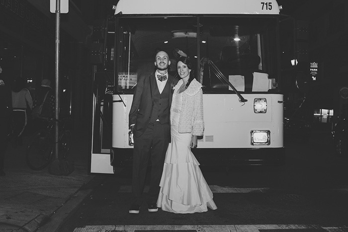 bride and groom in front of bus