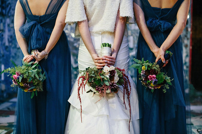 bridal party holding bouquets behind their backs