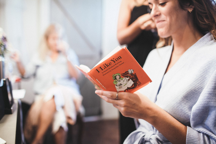 bride reading book while getting ready