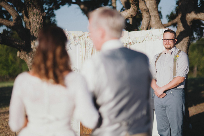 groom watching bride walk down the aisle