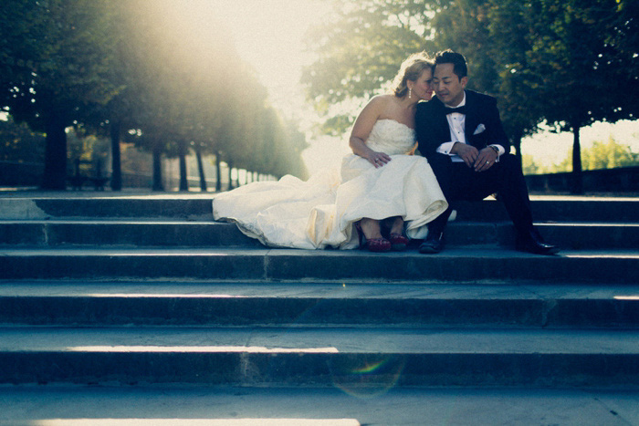 bride and groom sitting on Paris park steps