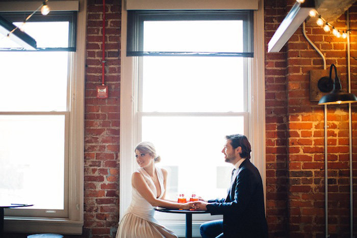 bride and groom sitting at table with cocktails