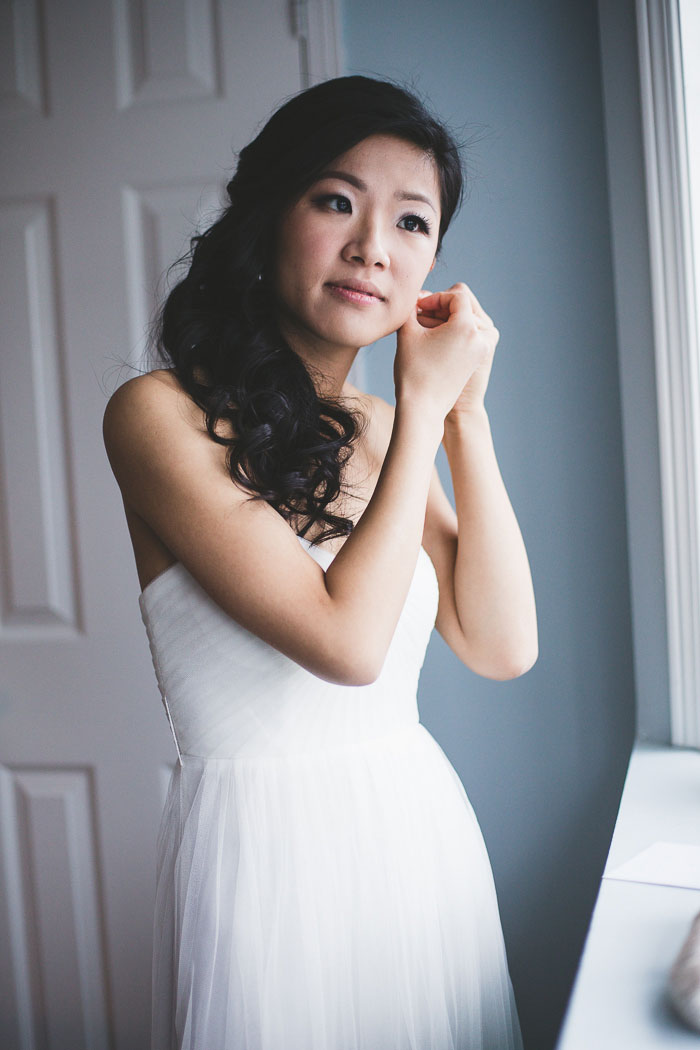 bride putting on earrings