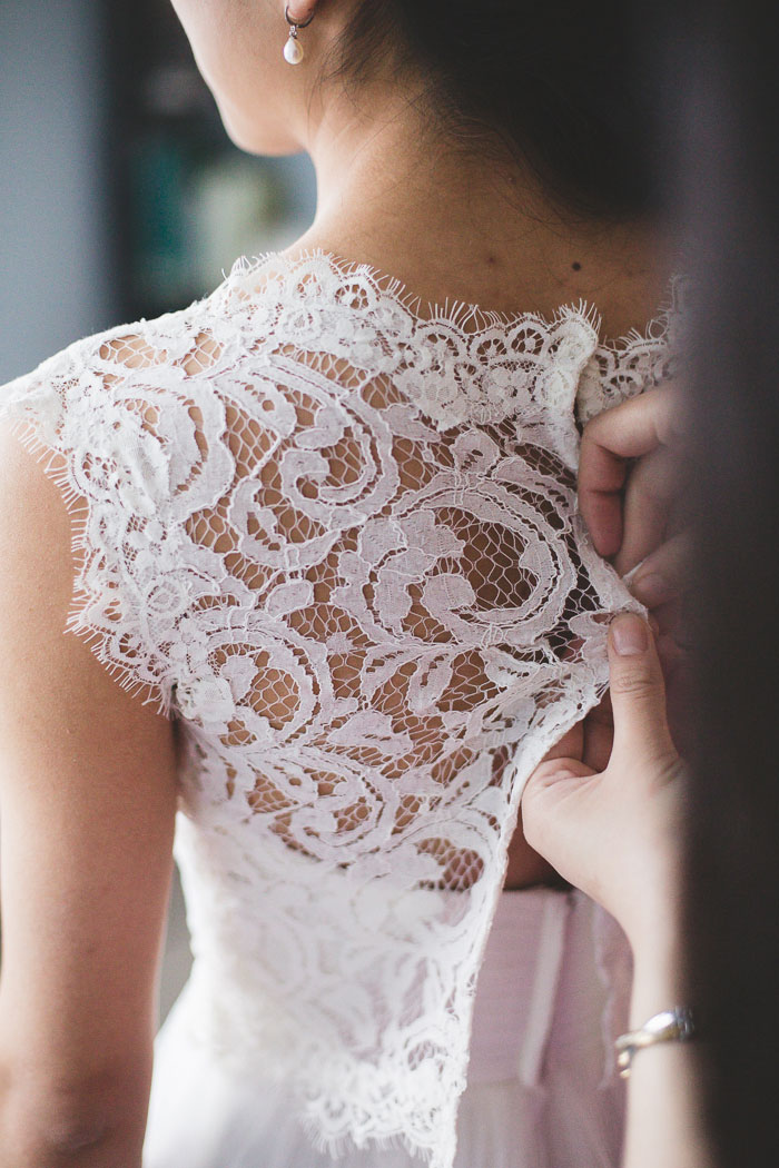 bride's dress being buttoned