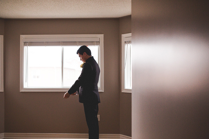 groom adjusting jacket sleeves