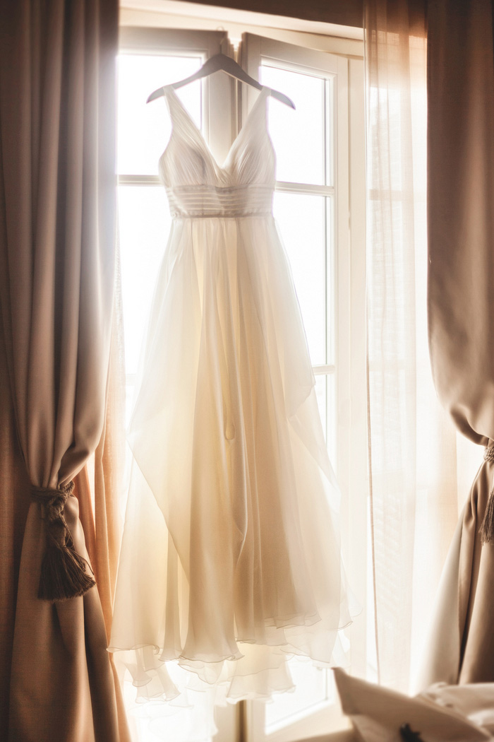 wedding dress hanging in window