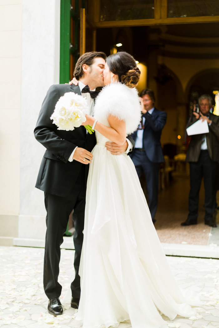 bride and groom kissing outside the church