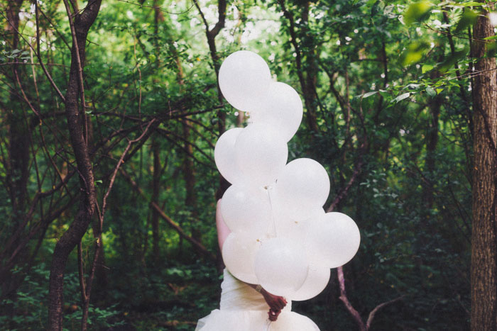 bride carrying white balloons