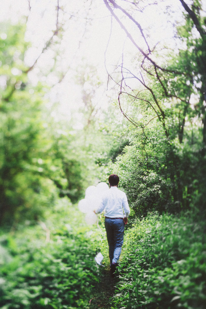 groom carrying white balloons