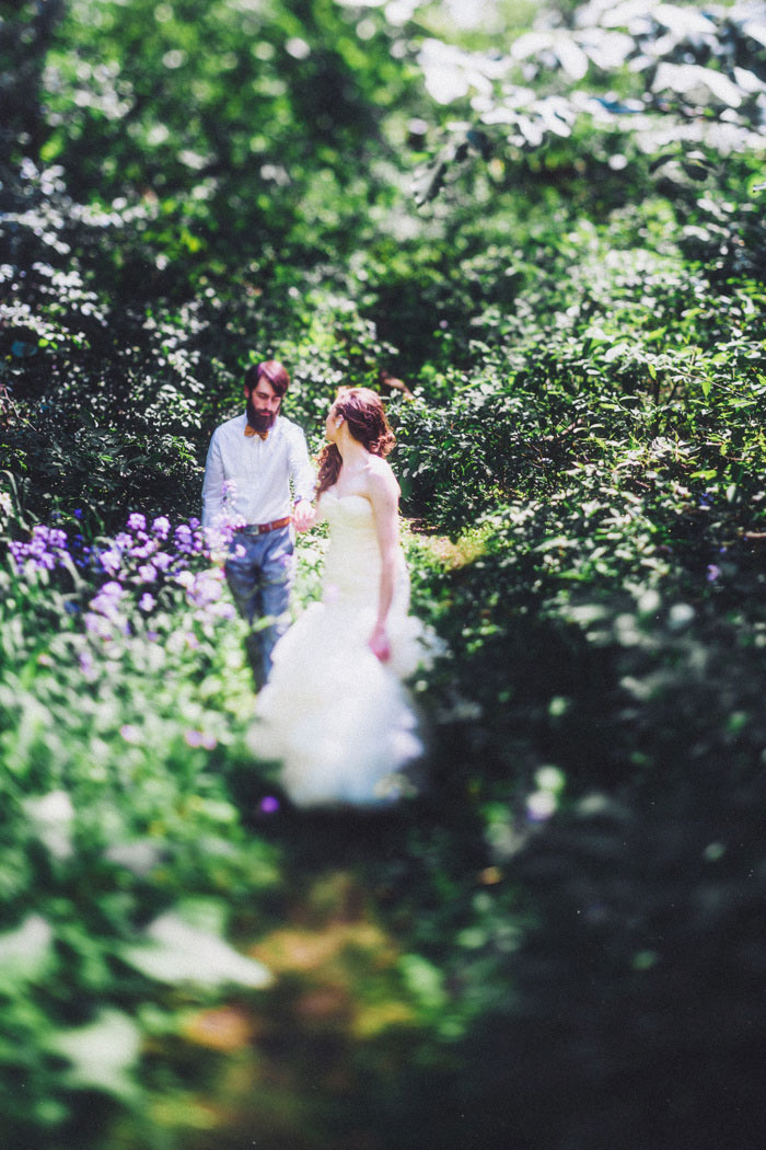 bride and groom walking through the woods