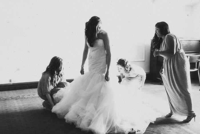 bridesmaids helping bride with her dress