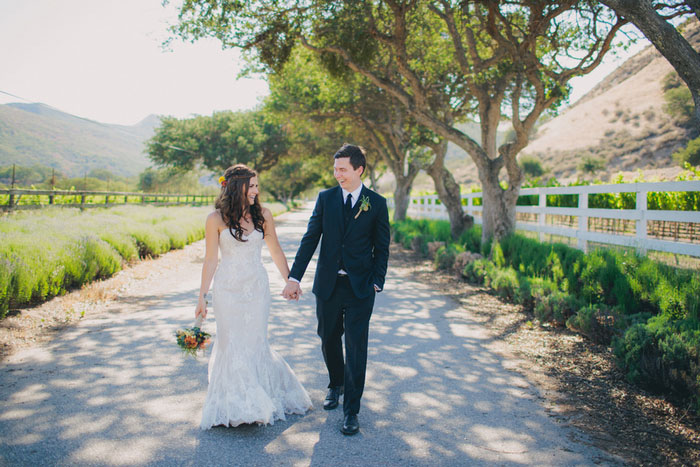 bride and groom walking down deserted road