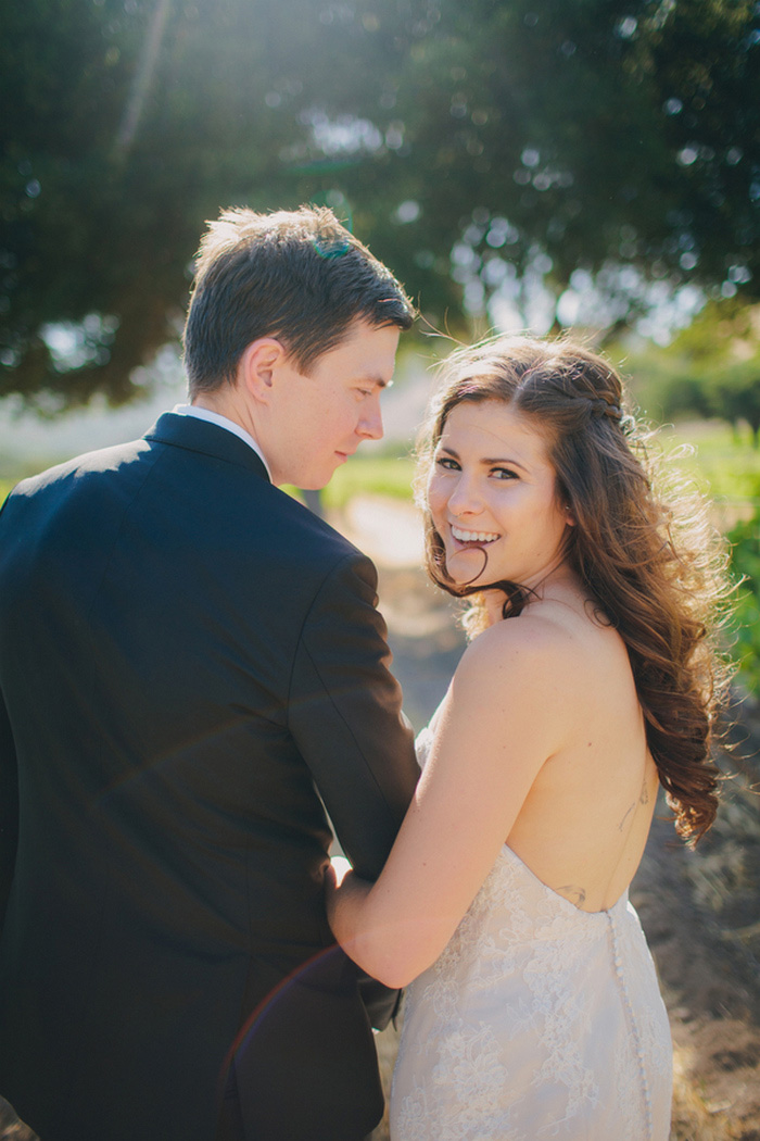 bride looking over her shoulder while walking with groom