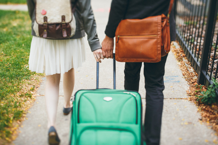 bride and groom walking with suitcase