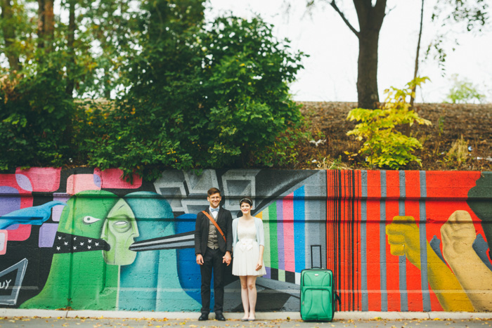 bride and groom in front of colorful mural