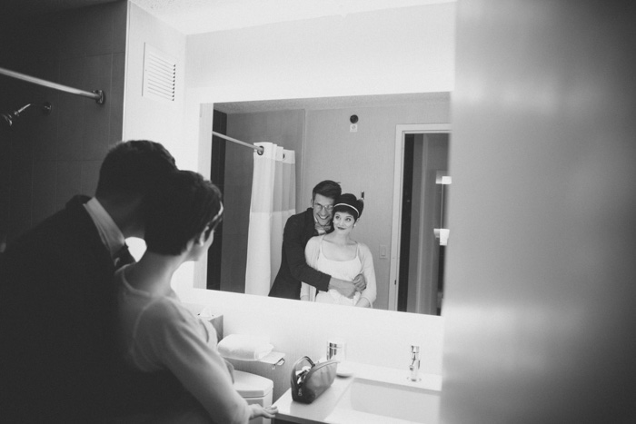 bride and groom posing in front of mirror