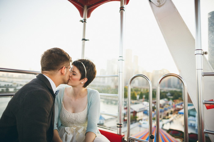 bride and groom kissing on ferris wheel