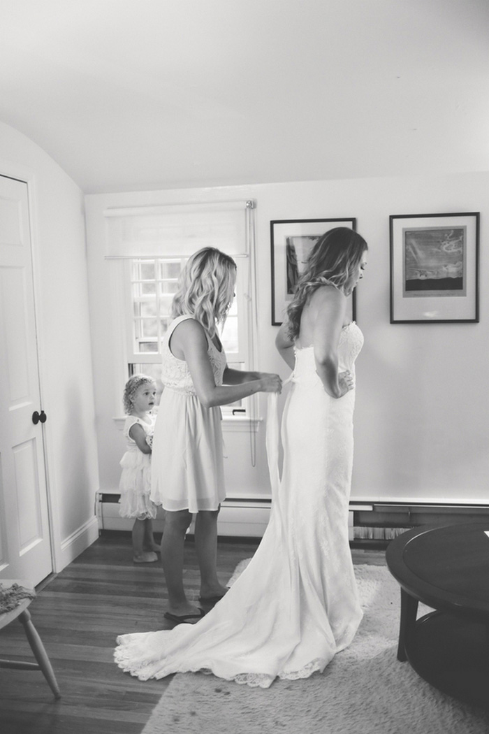 bride being zipped into dress