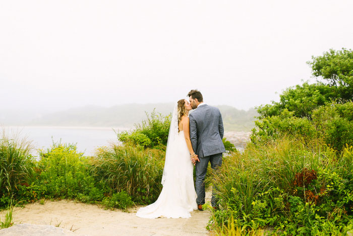 bride and groom kissing by the sea