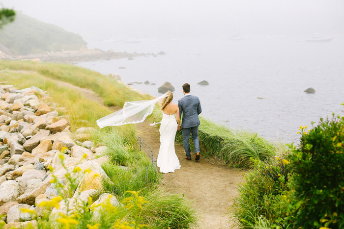 bride and groom walking towards the sea