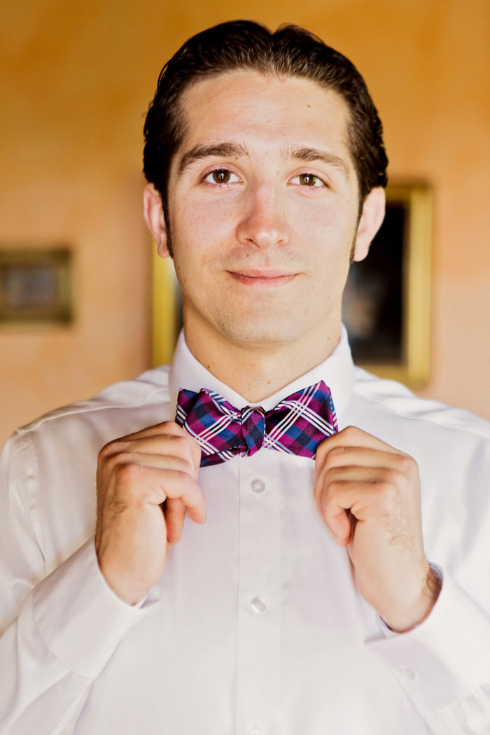 groom adjusting bow tie