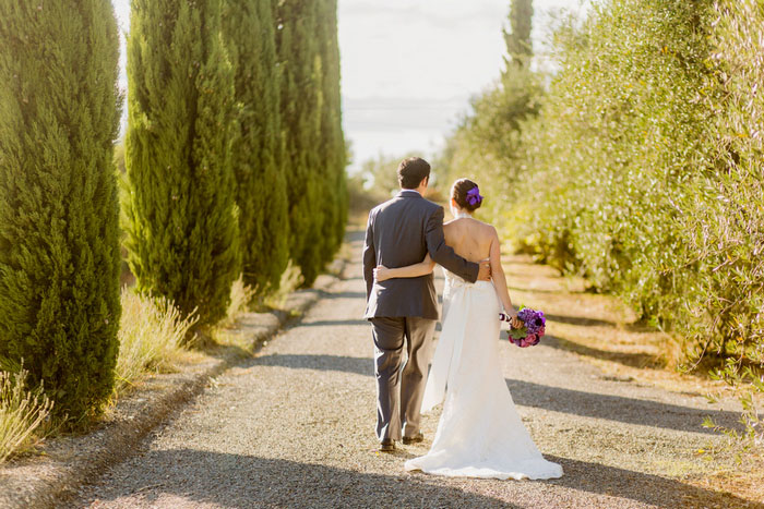 bride and groom walking down Tuscan Villa driveway