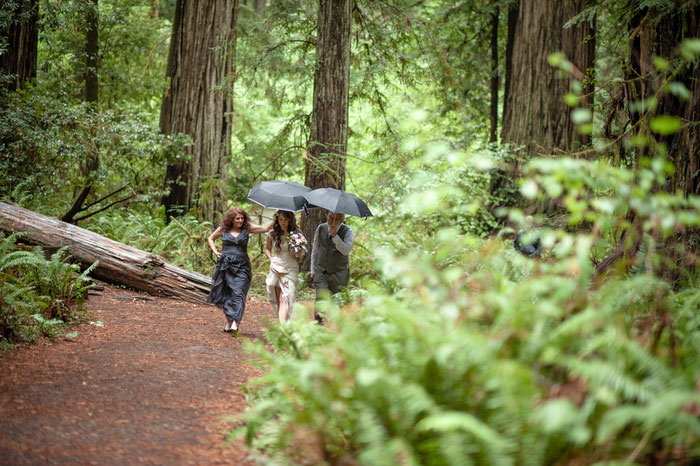 bride walking with her parents to ceremony site in the forest