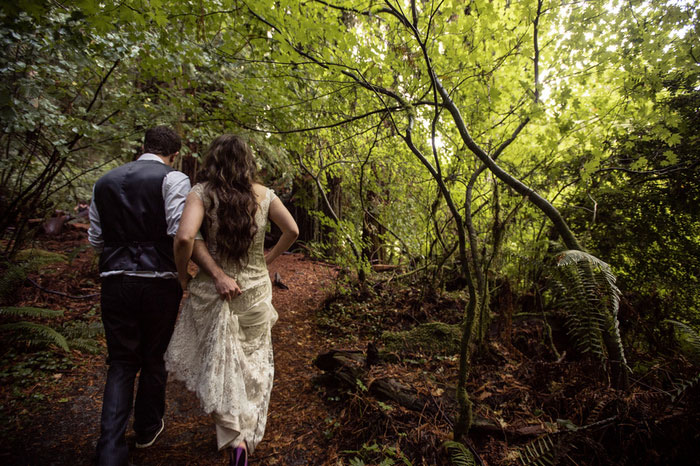 bride and groom walking in the woods