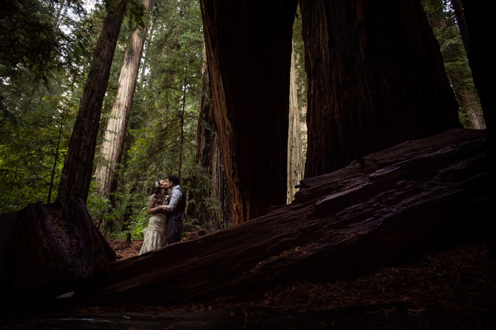 bride and groom kissing in the forest