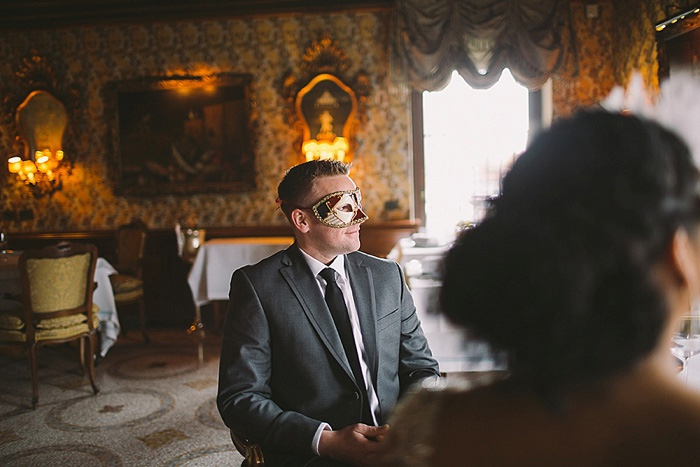 groom wearing masquerade mask