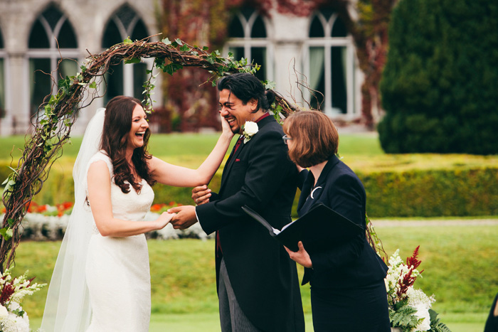 bride wiping away groom's tears during ceremony