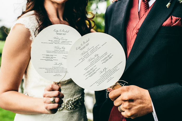 bride and groom holding wedding programs